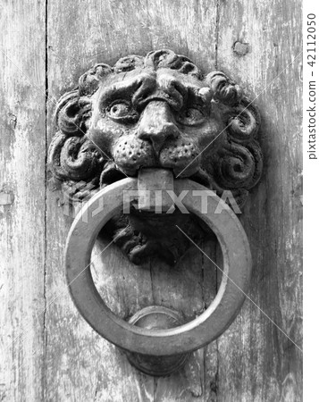 Vintage metal door knocker on old wooden door Vintage metal door knocker on old wooden door 42112050