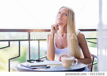 woman drink coffee and writing note book journal 42113019