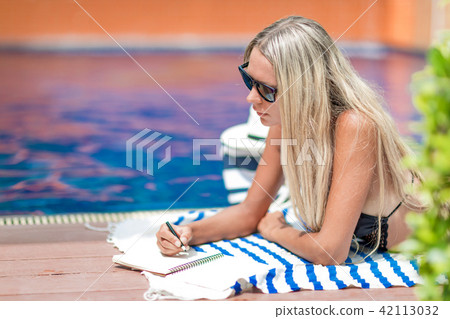 girl freelancer in bikini works near swimming pool girl freelancer in bikini works near swimming pool 42113032