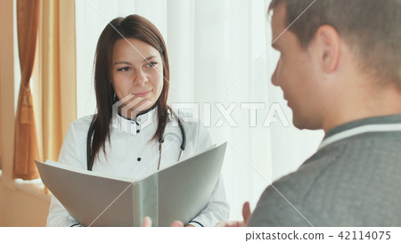 A patient guy and a young girl doctor gives advice in a hospital. A patient guy and a young girl doctor gives advice in a hospital. 42114075