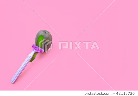 Kiwi fruit and razor on violet background. Hair removal concept. Kiwi fruit and razor on violet background. Hair removal concept. 42115726