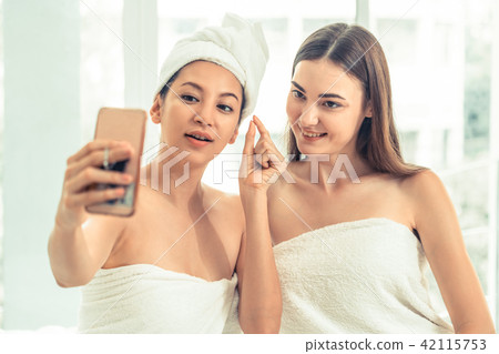 Happy women takes selfie with mobile phone in spa. 42115753