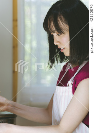 Woman cooking 42120076