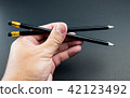 Close up of a man' s hand holding black pencil 42123492