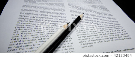 Opened text book with wooden black & white pencil 42123494