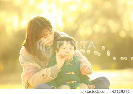 Parents and children playing with soap bubbles Parents and children playing with soap bubbles 42129271