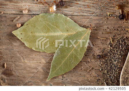 Top view of a wooden spoons full of paprica and black pepper on wooden barrel background, selective 42129505