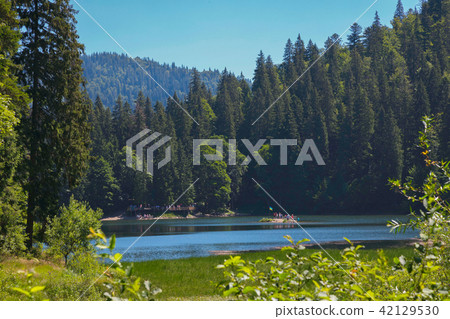 Tourists on a small island with a flag fluttering Tourists on a small island with a flag fluttering 42129530