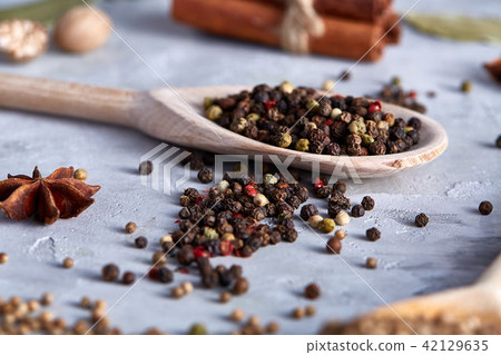 Peppercorns in wooden spoon with clipping path on white textured background, close-up, selective 42129635