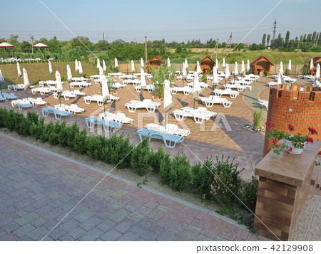 Beach area with white sun loungers, umbrellas and  42129908