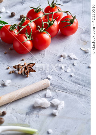 Cherry tomatoes and assorted spices on white textured background, flat lay, close-up, selective Cherry tomatoes and assorted spices on white textured background, flat lay, close-up, selective 42130516
