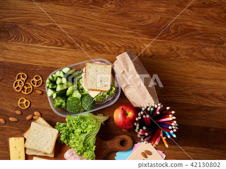 Concept of school lunch break with healthy lunch box and school supplies on wooden desk, selective 42130802