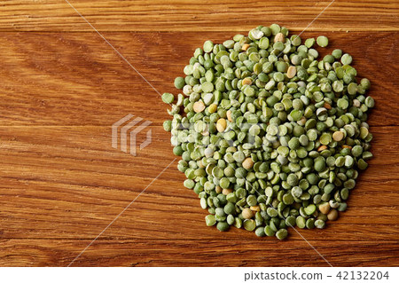 Pile of green peas on rustic wooden background, close-up, top view, selective focus. 42132204