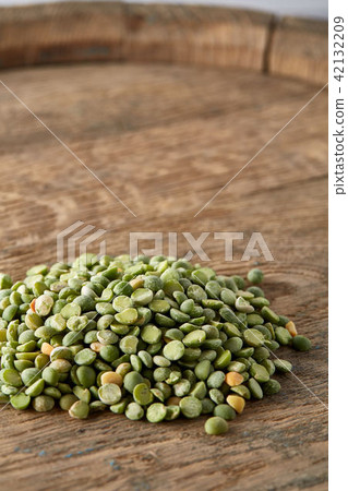 Pile of green peas on the top of wooden barrel, close-up, top view, selective focus. 42132209