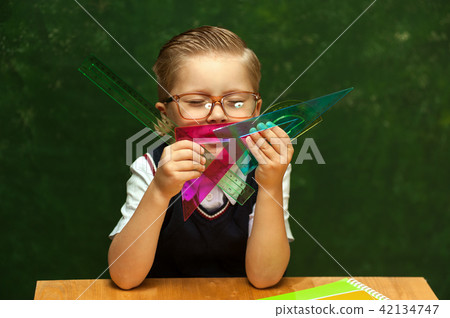 Positive cute little boy posing at school desk 42134747
