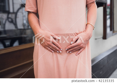 Woman's hands on lower abdomen 42135335