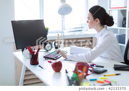Young girl in the office working with documents at the computer. 42135370
