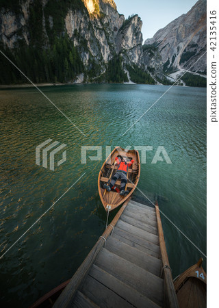 man seating on boat on lago di braies, italien dol 42135416