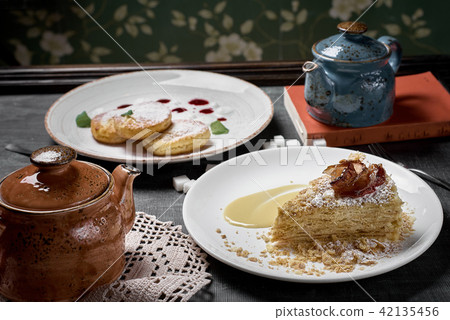 Various desserts, cheese cakes dessert, napoleon cakes, kettle with tea Various desserts, cheese cakes dessert, napoleon cakes, kettle with tea 42135456