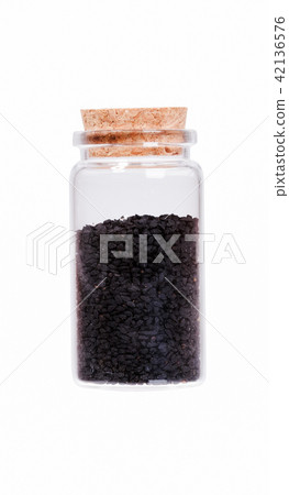 Nigella or Black cumin in a glass bottle with cork stopper, isol 42136576