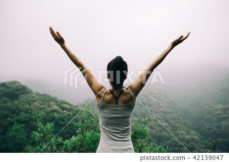 Happy woman  outstretched arms on  mountain valley 42139047