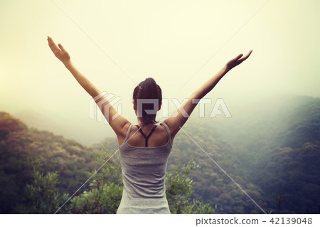 Happy woman outstretched arms on mountain valley Happy woman outstretched arms on mountain valley 42139048