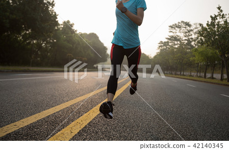 Fitness sportswoman running on sunrise trail 42140345