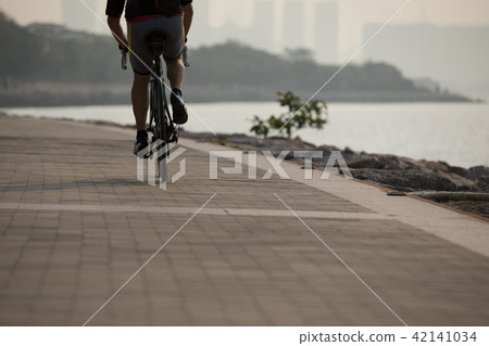 cyclist riding bike on seaside cyclist riding bike on seaside 42141034