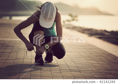 tying running shoes getting ready for jogging 42142284