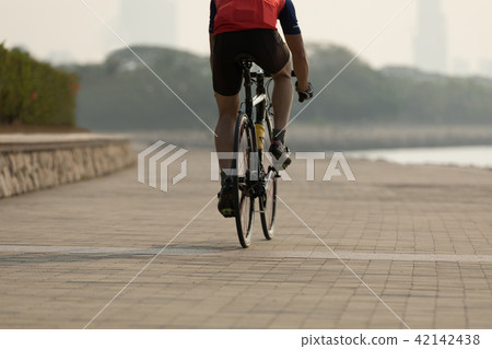 cyclist riding bike on seaside 42142438