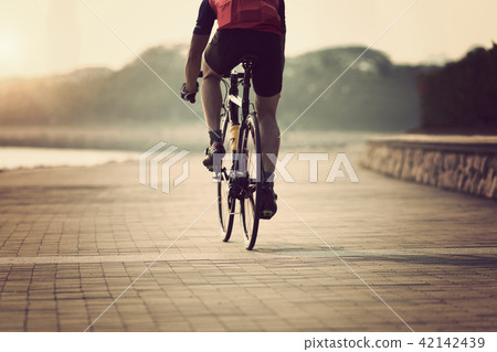 cyclist riding bike on seaside 42142439