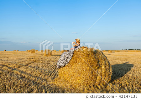 Happy girl on field of wheat with bread Happy girl on field of wheat with bread 42147133