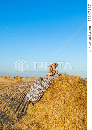 Happy girl on field of wheat with bread Happy girl on field of wheat with bread 42147137