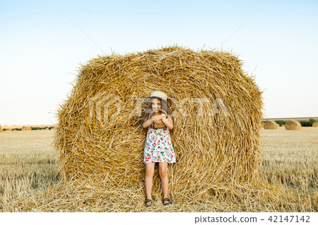 Happy girl on field of wheat with bread Happy girl on field of wheat with bread 42147142
