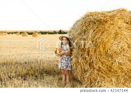 Happy girl on field of wheat with bread Happy girl on field of wheat with bread 42147144
