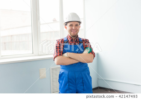 Happy caucasian male builder with crossed hands wearing white helmet Happy caucasian male builder with crossed hands wearing white helmet 42147493