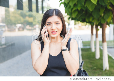 Portrait of a shocked young girl speaking on phone Portrait of a shocked young girl speaking on phone 42148559