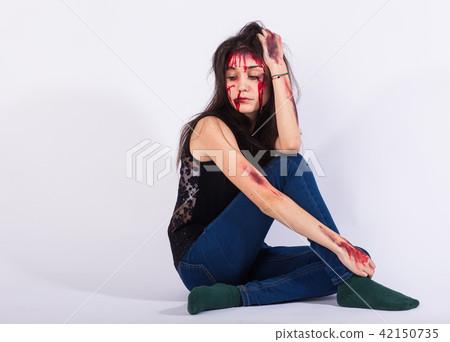 Beaten sad woman victim of domestic violence and abuse stands with bruises and wounds on her face Beaten sad woman victim of domestic violence and abuse stands with bruises and wounds on her face 42150735