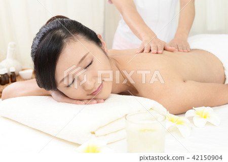 A woman receiving a body massage A woman receiving a body massage 42150904