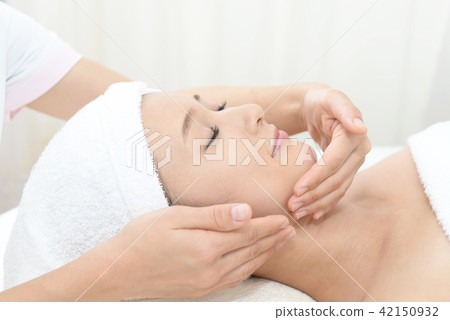 A woman receiving a facial massage A woman receiving a facial massage 42150932