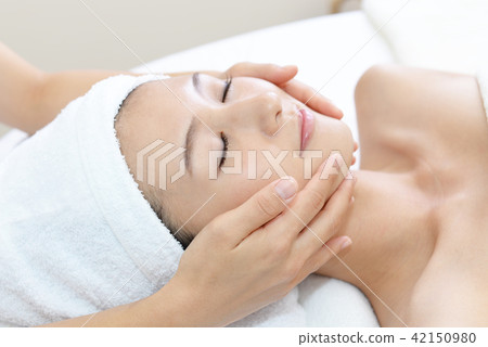 A woman receiving a facial massage A woman receiving a facial massage 42150980
