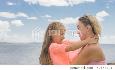 Little cute girl and young mother at beach. Little cute girl and young mother at beach. 42154794