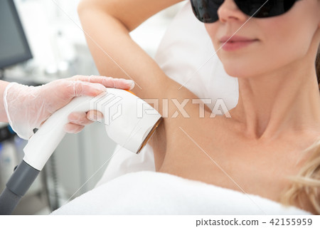 Glad female getting hair removal with gadget 42155959
