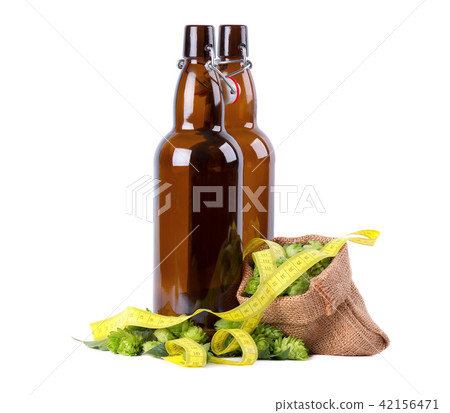 Glass bottles for kraft beer with fresh green branch of hops and yellow measuring tape, isolated on 42156471