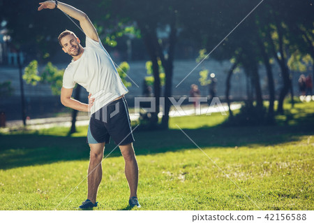 Cheerful athlete training in park Cheerful athlete training in park 42156588