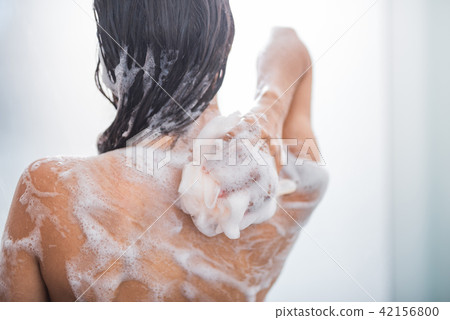 Woman rubbing body with foam 42156800