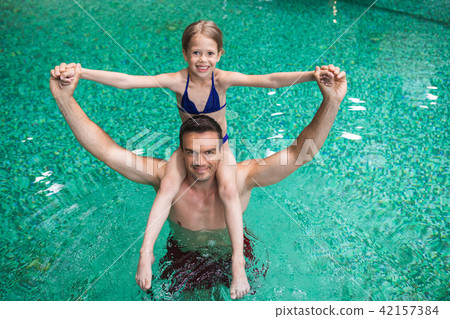 Pleased man with daughter in pool 42157384