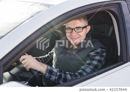 Attractive happy man in good white car Attractive happy man in good white car 42157644