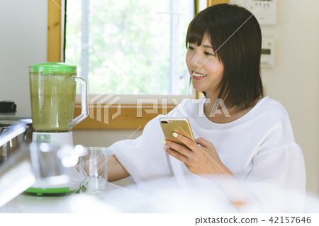 A woman making a smoothie A woman making a smoothie 42157646