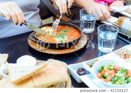Family having traditional Israeli breakfast Family having traditional Israeli breakfast 42158327